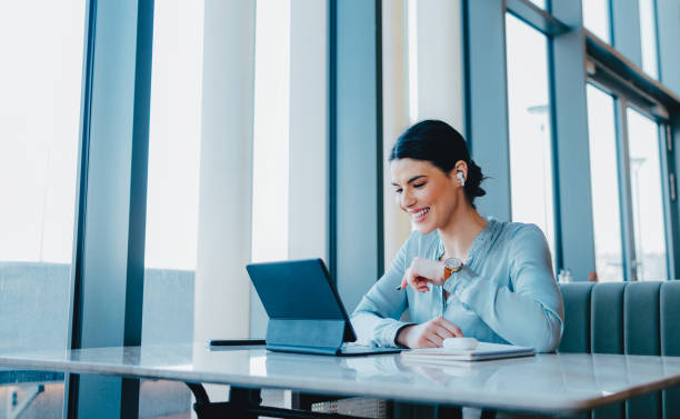 Person wearing Halo Air Pro wireless earbuds while working on laptop in modern office setting